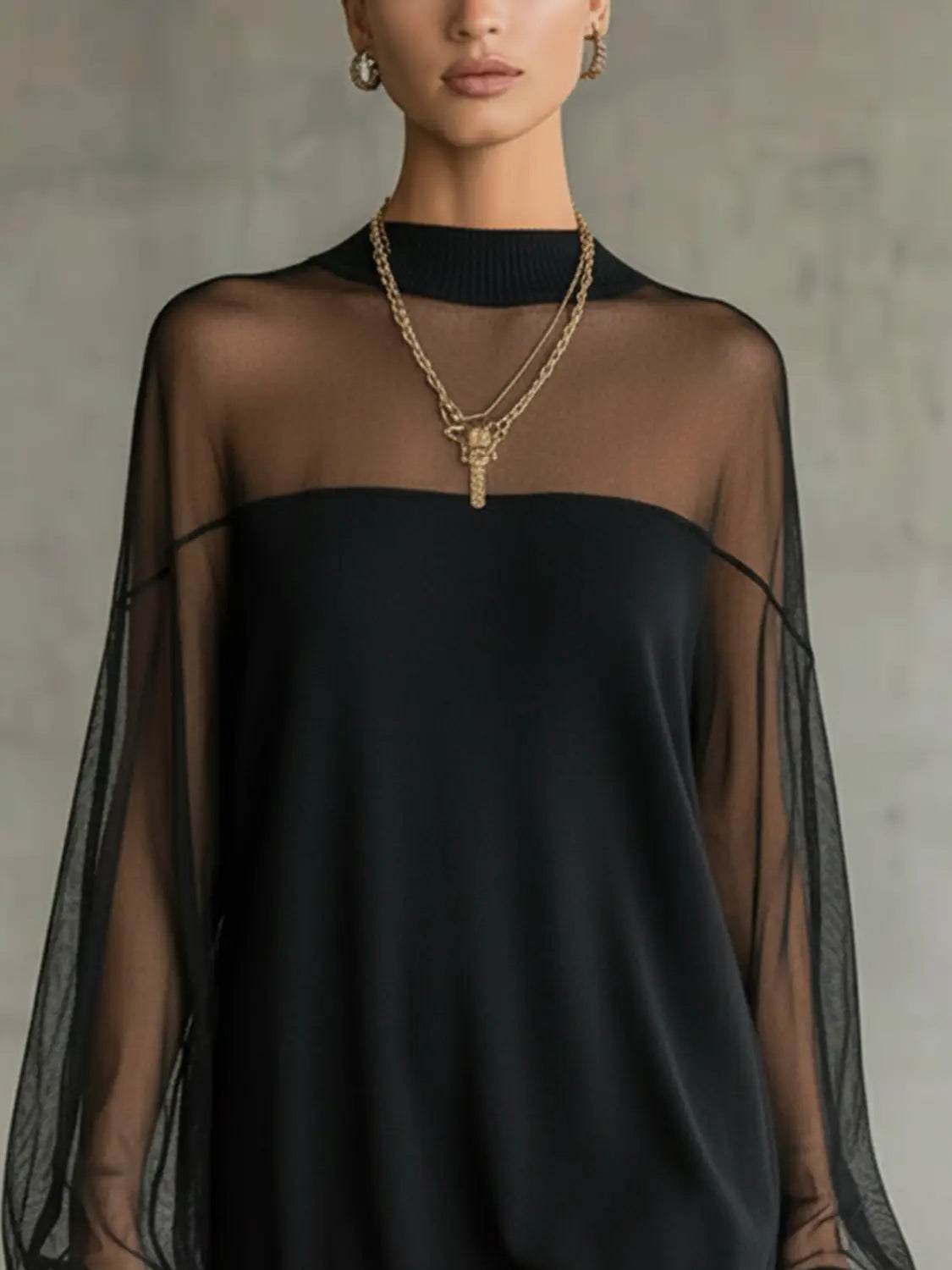 Black sheer chiffon top with high neckline and long flowing sleeves as part of an elegant black mesh patchwork long sleeve mini dress.