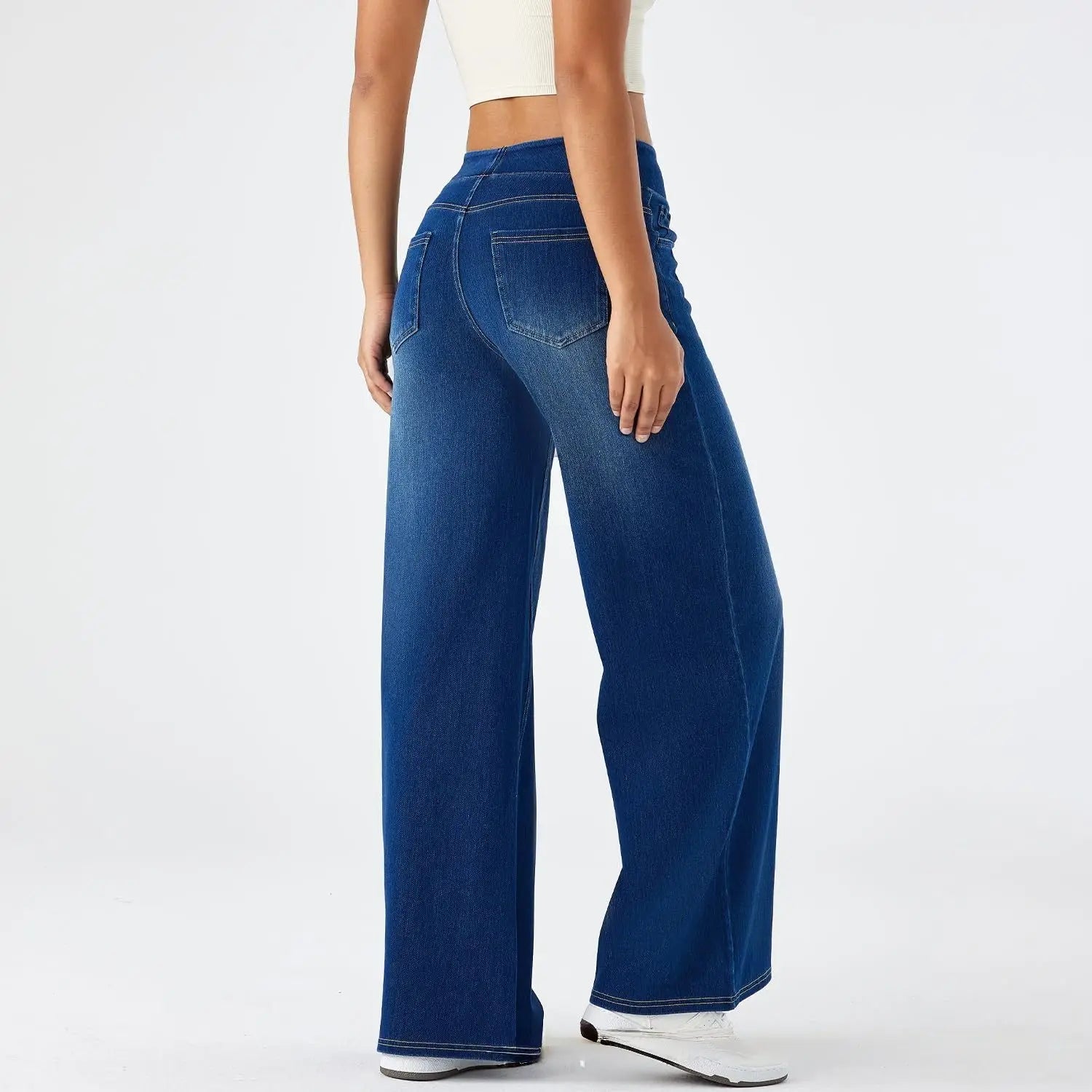 Jeans en denim bleu à jambes larges taille haute avec poches arrière classiques montrés depuis l’arrière.