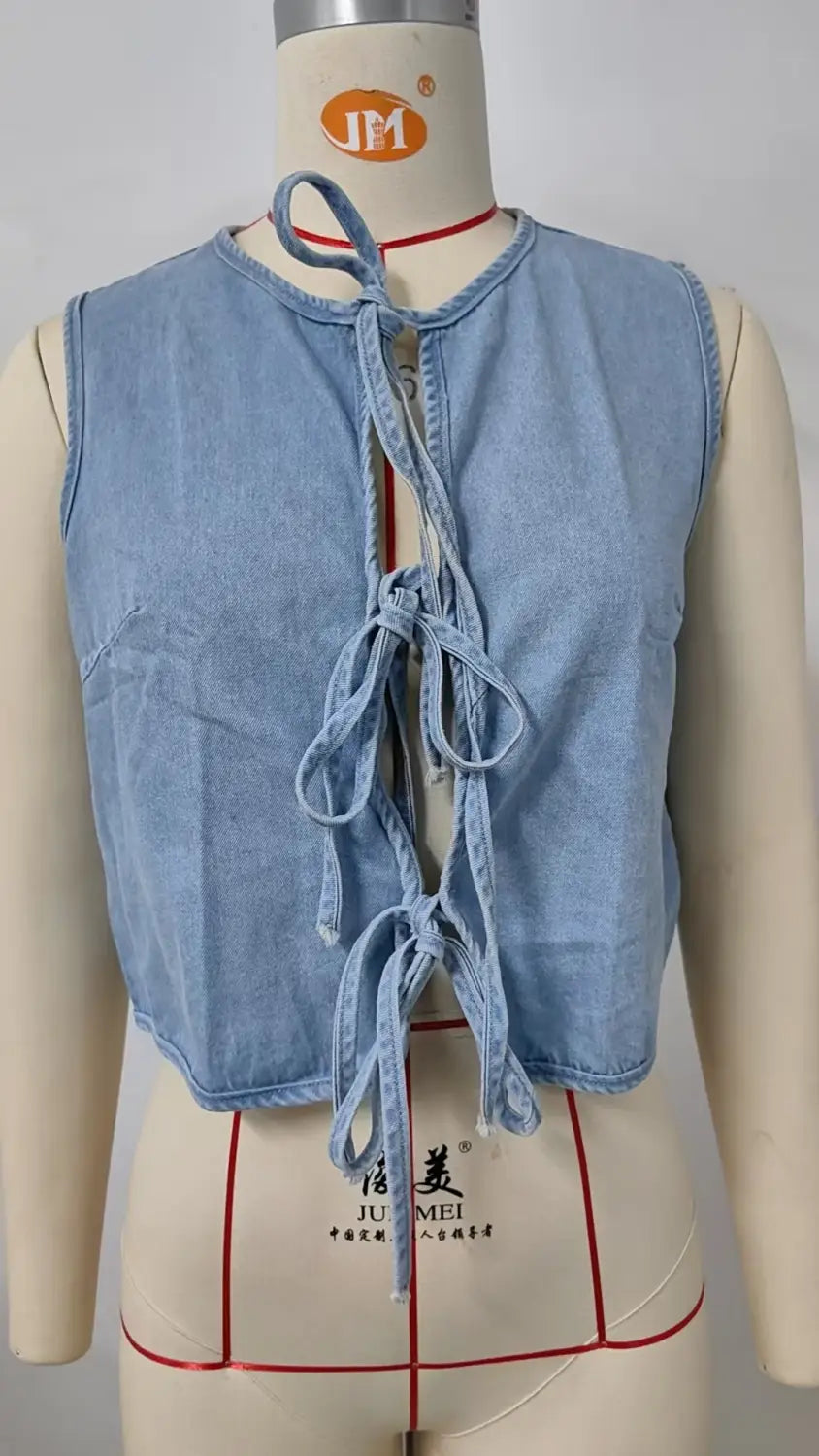 Light blue denim sleeveless crop top with a tie-front bow tie design in a Y2k style.