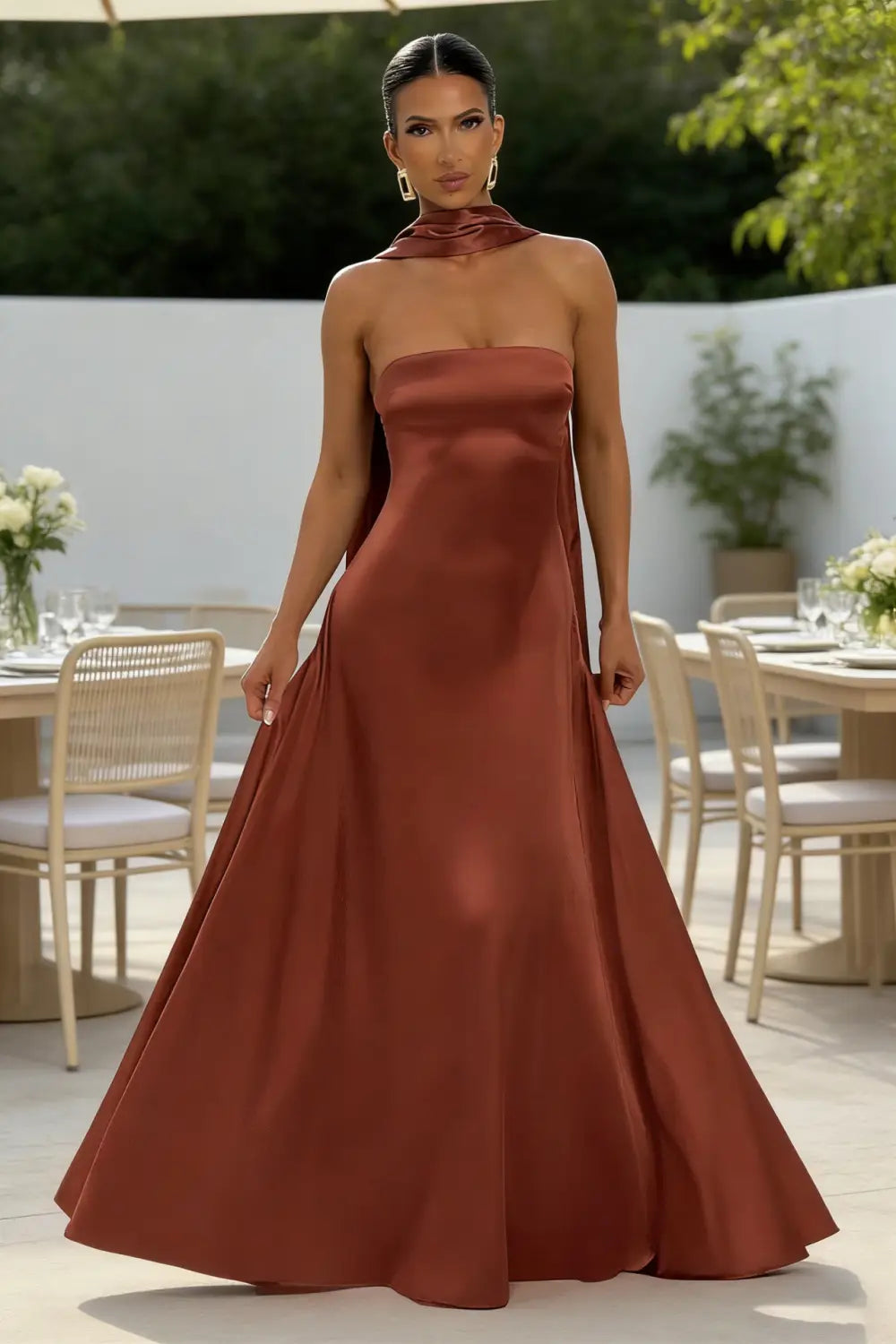 Un vestido de noche de satén color óxido sin tirantes, fluido, con escote alto y mangas anchas.