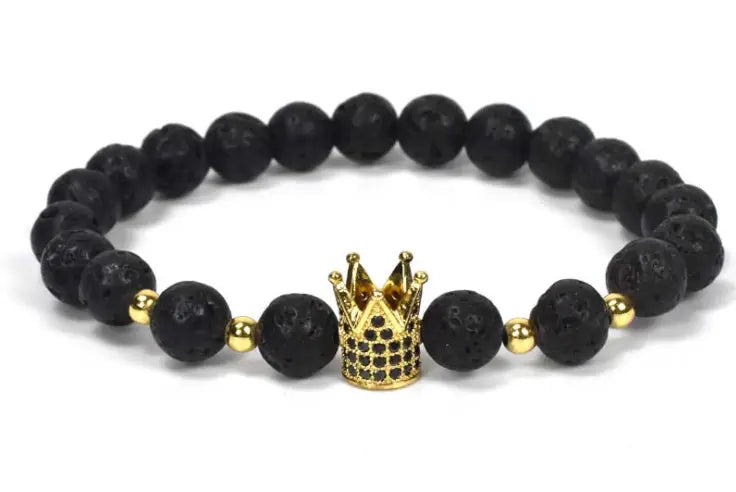 Black lava stone bracelet featuring a gold crown charm and small golden beads as part of the natural lapis lazuli and lava stone owl charm bracelet collection.
