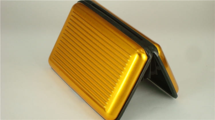 Gold-colored ribbed metal RFID blocking aluminum alloy card holder case with black trim.