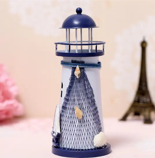 Mediterranean lighthouse garden statue decor featuring a nautical-themed miniature lighthouse with a navy blue dome and base, white body with gray netting and decorative seashells.