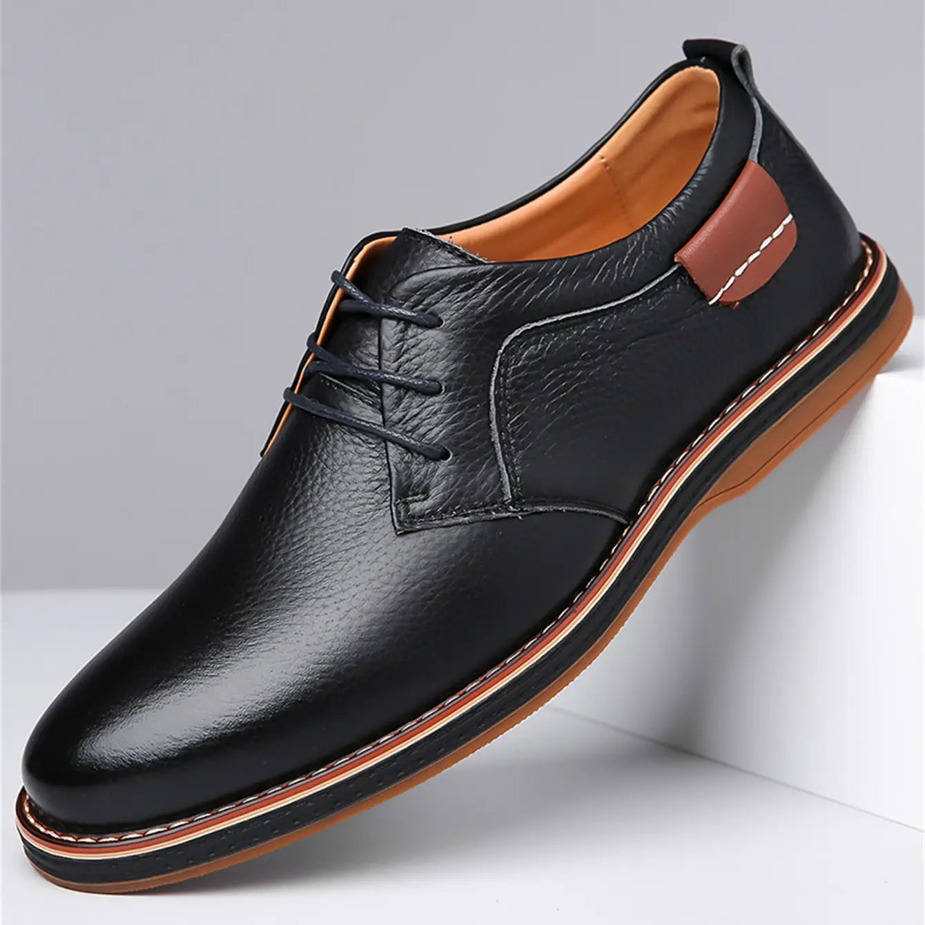 Men’s handmade genuine leather lace-up oxford shoe in black with brown accents and tan lining.
