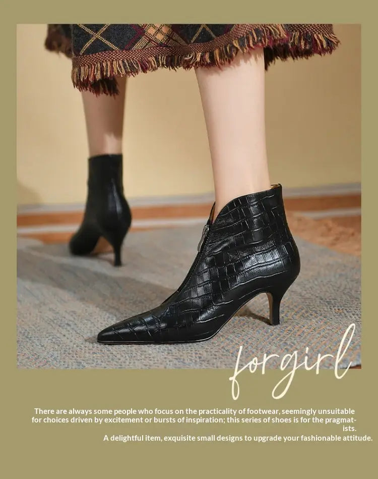 Black crocodile-embossed leather stiletto ankle boot with a pointed toe and slender heel shown from the back side.