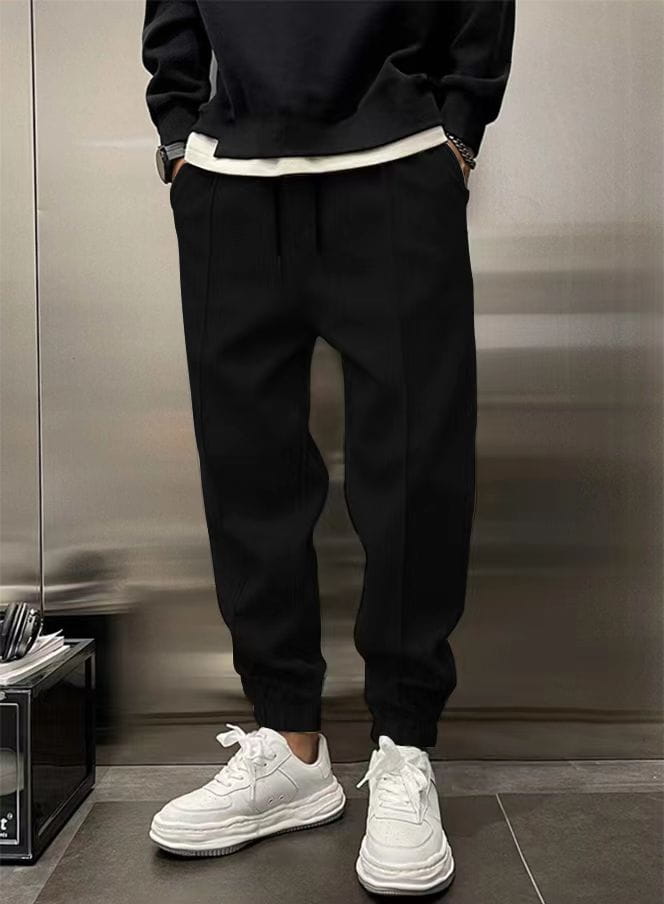 Men’s fleece drawstring sweatpants in black tapered jogger style with a white inner waistband and ribbed cuffs.