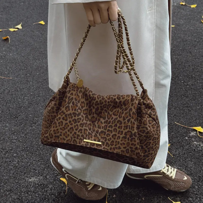 Brown leopard-print suede crossbody bag with gold-tone chain strap and matching metallic clasp.
