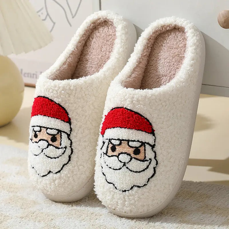 White fuzzy winter slippers featuring embroidered Santa Claus faces with red hats and white beards from the festive embroidered Santa and reindeer collection.