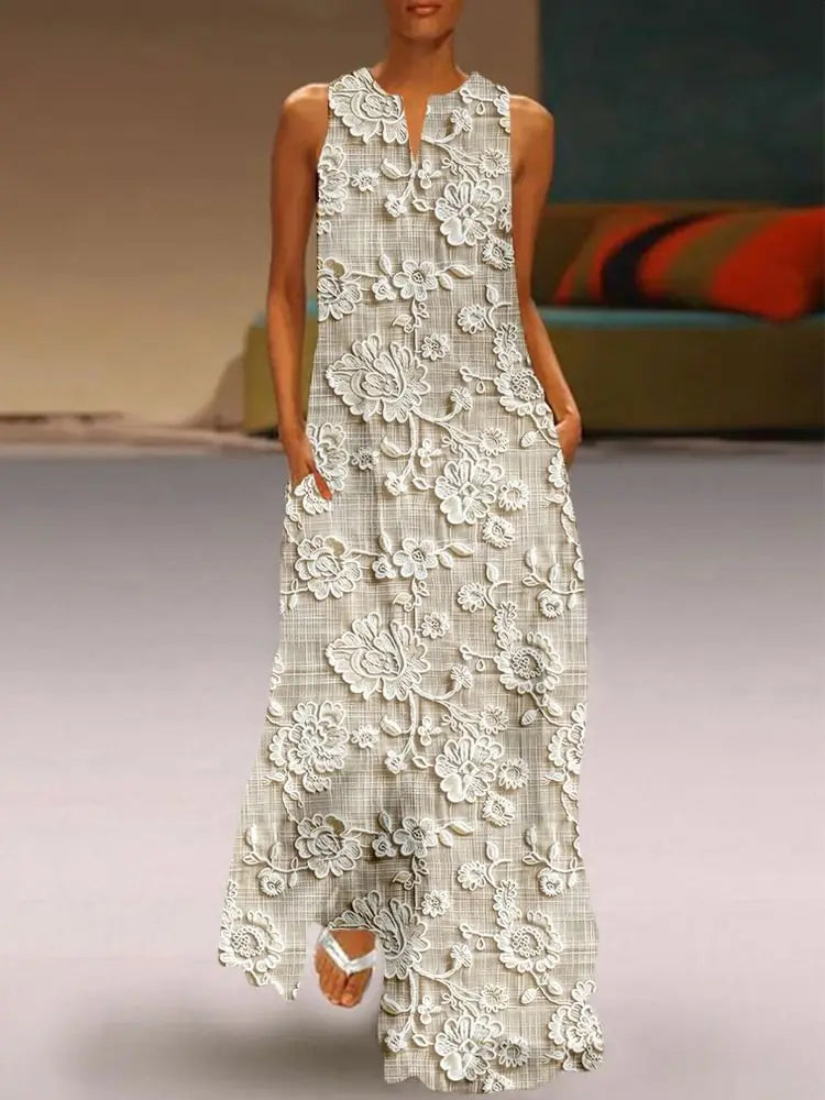 Une robe longue maxi sans manches, de longueur jusqu’au sol, en gris clair et blanc, présentant une dentelle florale appliquée complexe sur une base en tissu à carreaux discrets.
