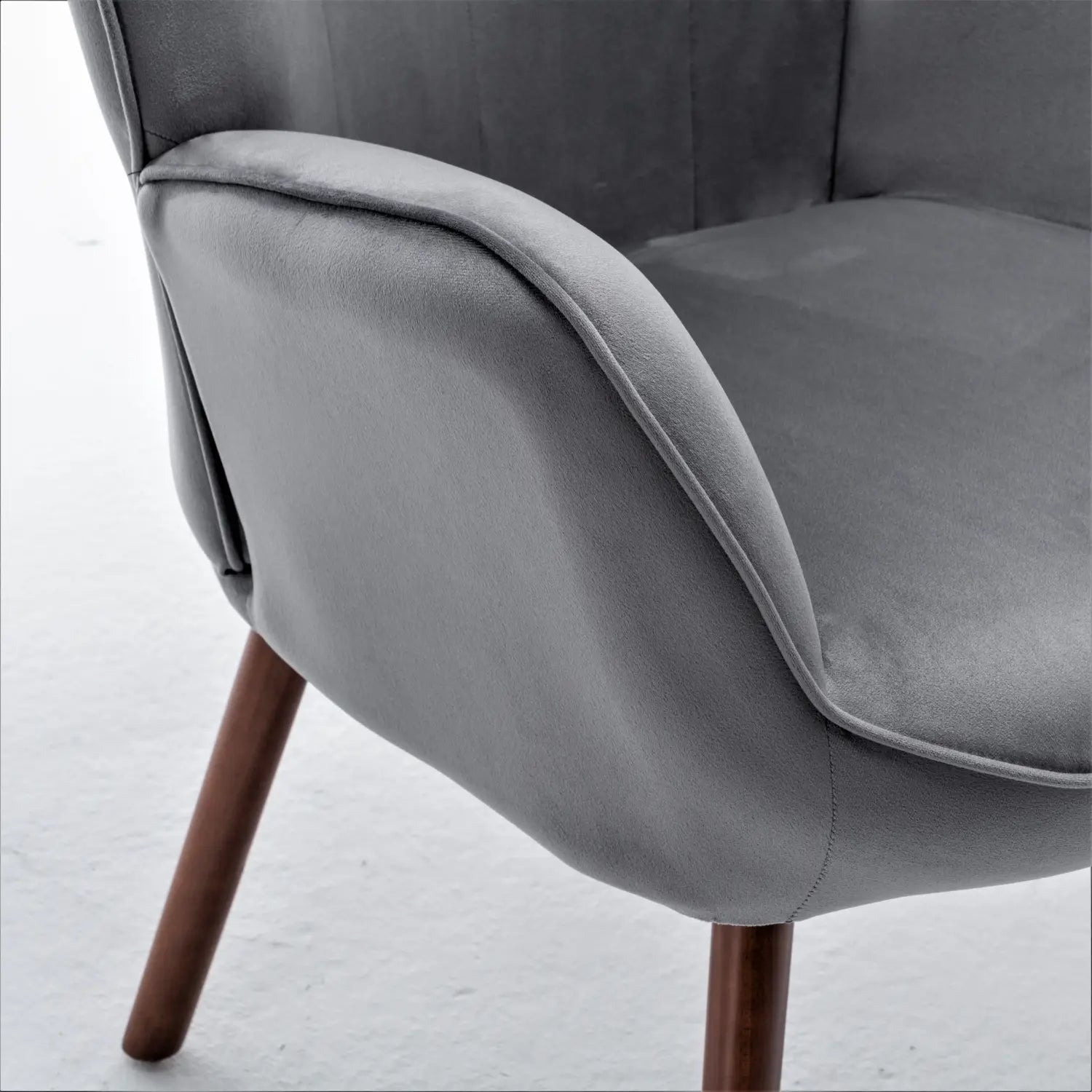 Grau Samt-Mid-Century-Wingback-Akzentstuhl mit hölzernen Beinen, von vorn gezeigt.