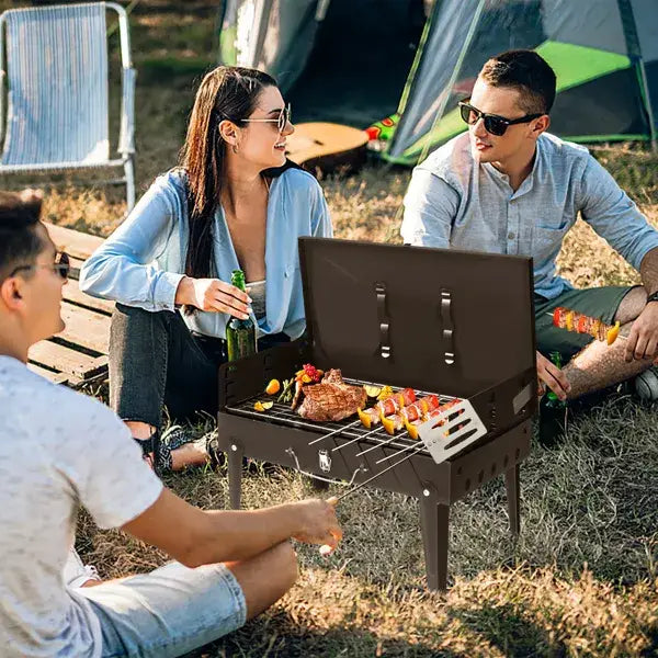 Black portable charcoal grill with foldable legs and built-in spatula made of steel for outdoor barbecue use measuring 44cm in a square design.