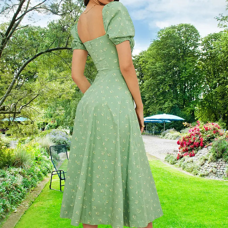 A soft sage green floral square neck puff sleeve midi slit dress with delicate white floral embroidery shown from the back.