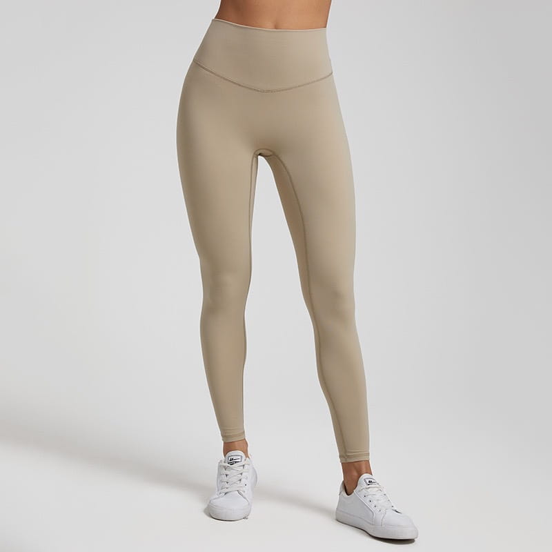 Beige high waisted stretch fitted leggings made of stretchy, form fitting fabric.