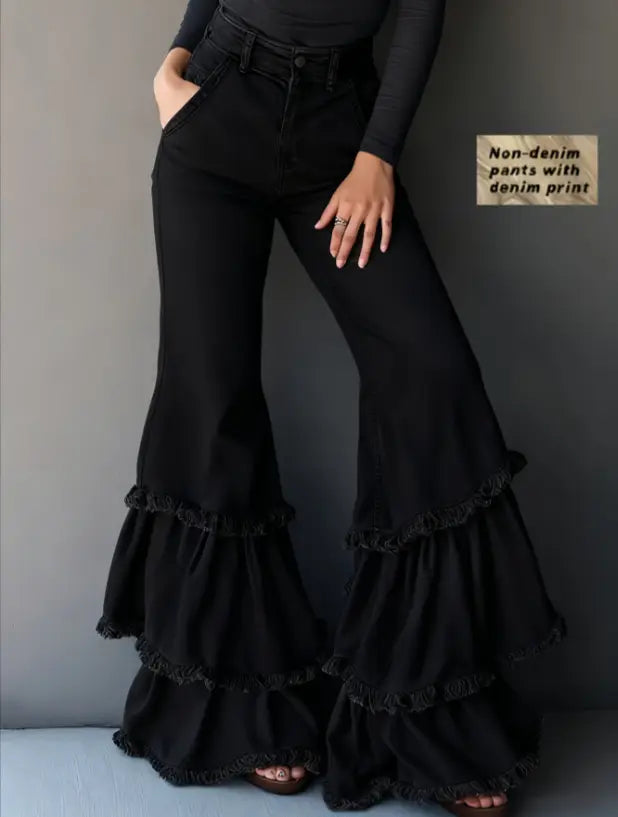 Black flared pants with a denim print and layered ruffle detailing at the hem.