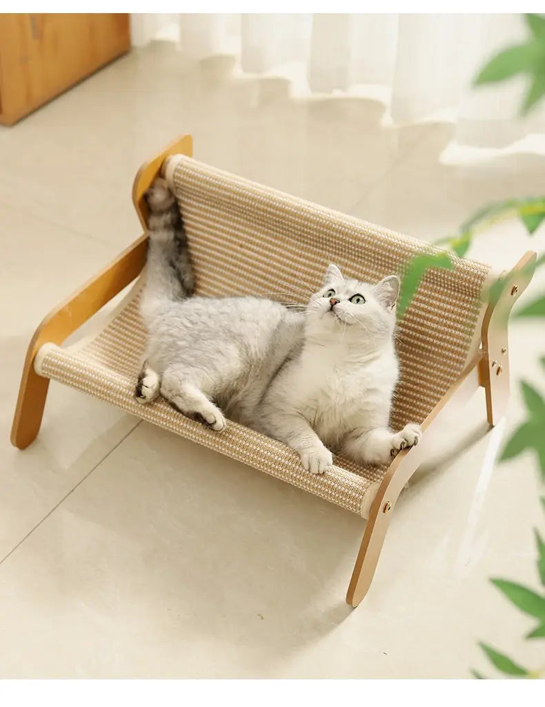 Nido cama tipo sillón reclinable de ratán con tabla de rascado para gatos tejido en beige, acogedor, con estructura de madera color claro, superficie acolchada y reposabrazos curvados.