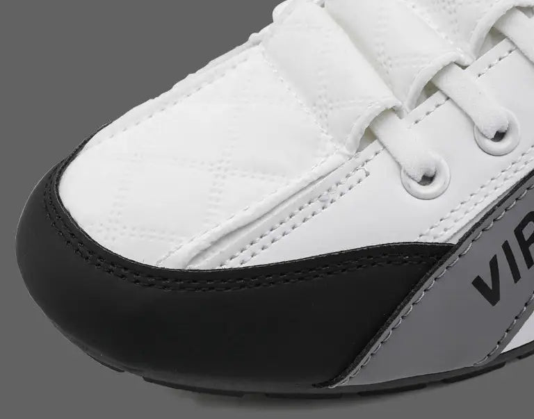 Men’s low top quilted athletic fashion sneakers in white and black with a quilted upper, velcro strap closure, and gray side panel featuring the vir logo.