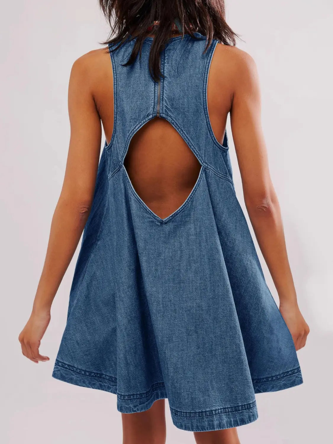 Rückseite eines ärmellosen Jeans-Minikleids in mittlerer Waschung mit einem markanten Ausschnitt und Schleifen-Detail