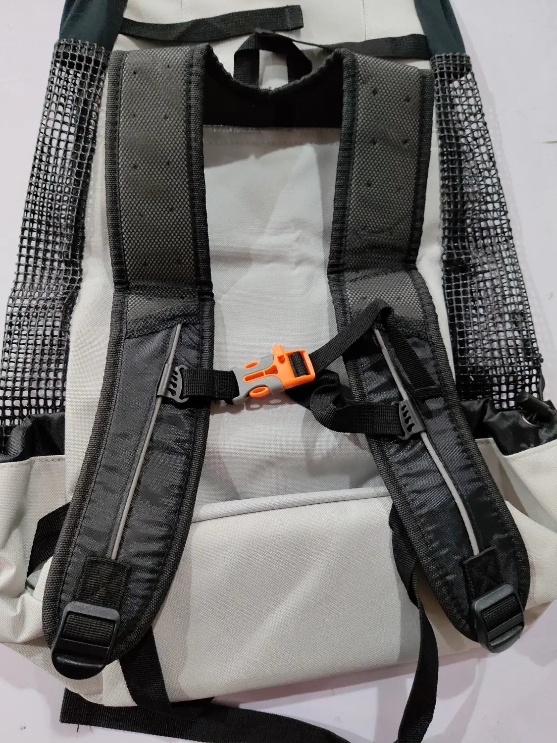 Breathable dog backpack mesh pet carrier in gray shown from the back with black mesh sides, adjustable shoulder straps, orange buckle, and reflective striping.