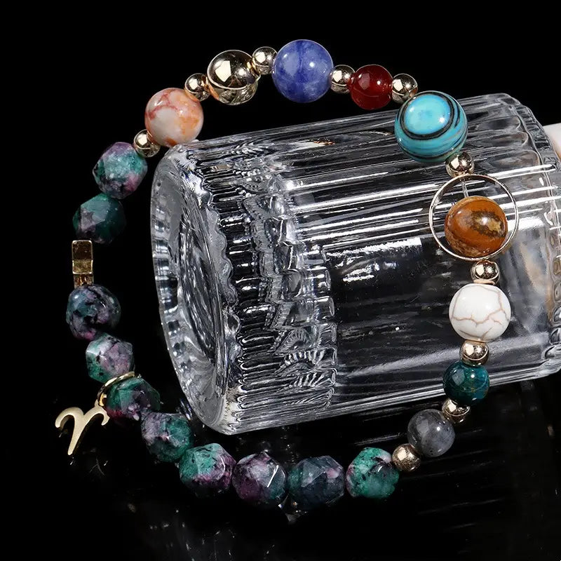 Natural stone zodiac constellation beaded bracelet featuring a colorful mix of polished blue red turquoise green and white gemstones accented with small gold-toned metallic beads and a golden Aries charm.