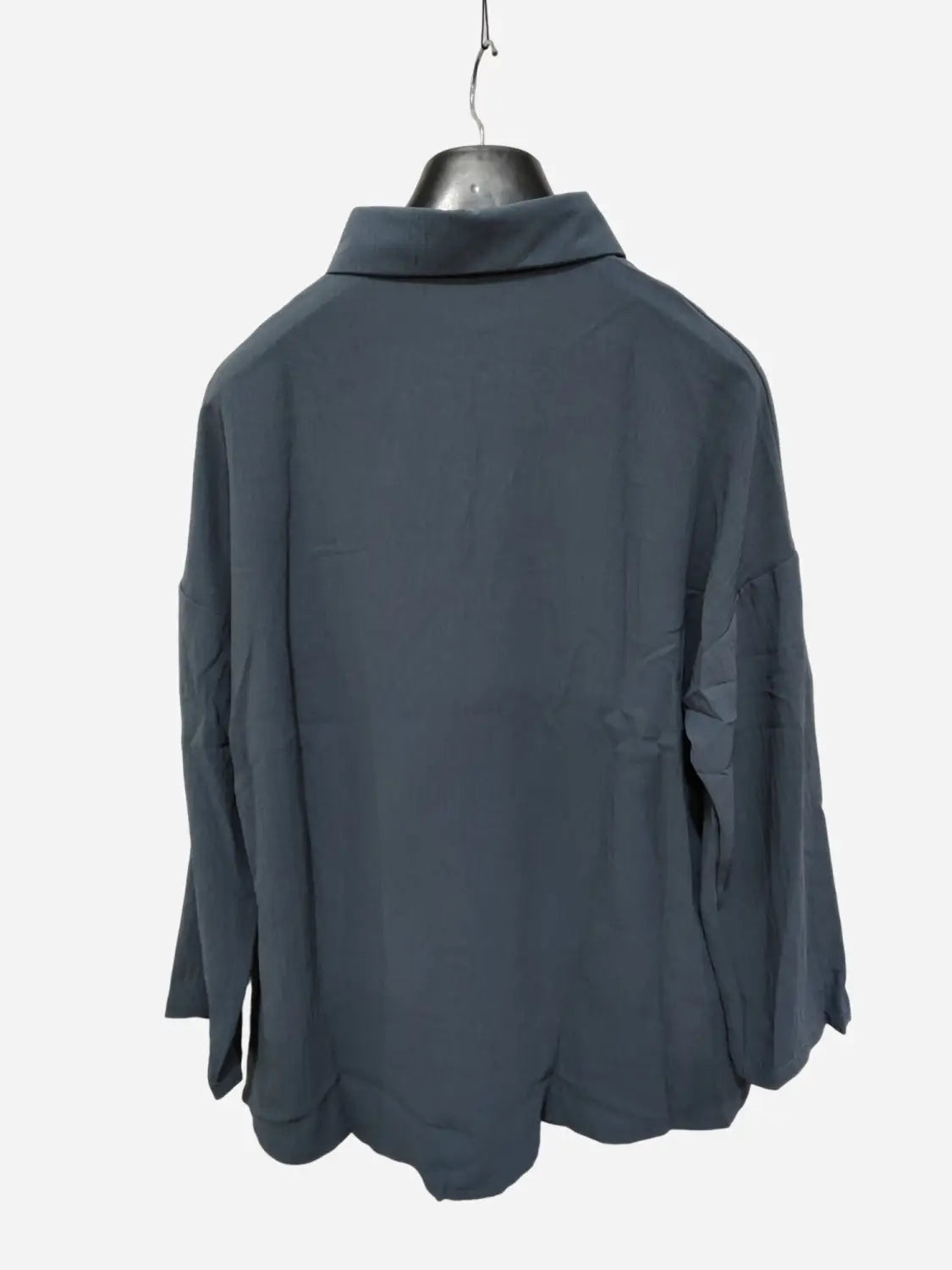 Dark gray long-sleeved women’s relaxed pleated button up shirt with collar and rolled sleeves in a slightly loose fit.