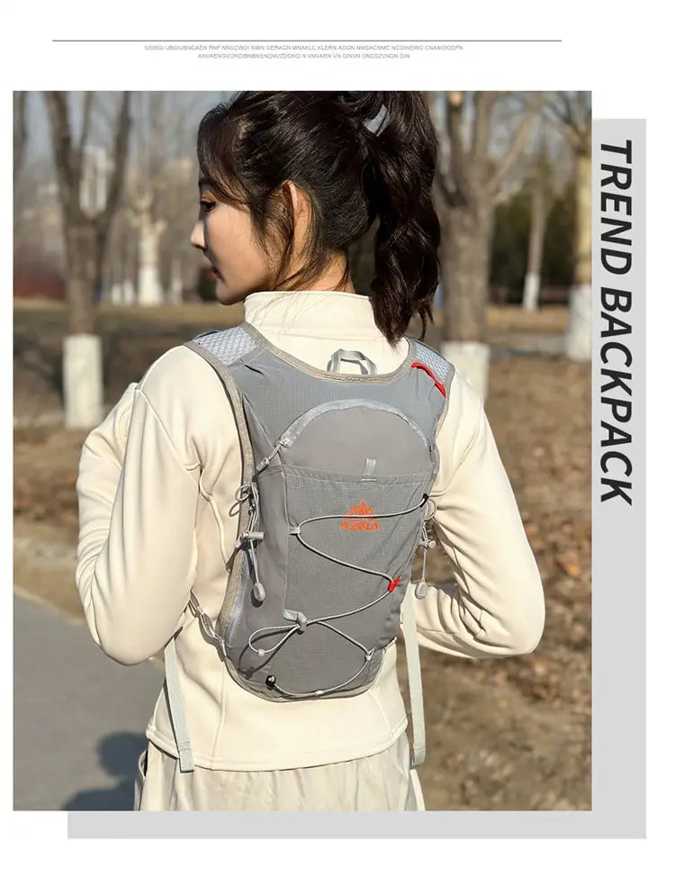 Gray hydration backpack lightweight running vest 20l with mesh panels and orange logo designed for outdoor activities shown from the back side.