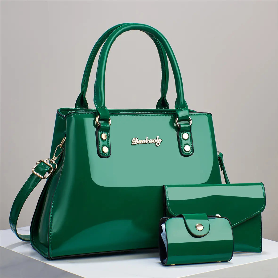 Glossy patent leather shiny emerald green handbag with gold-tone hardware and dianbooly logo plaque from a 3-piece handbag and wallet set.