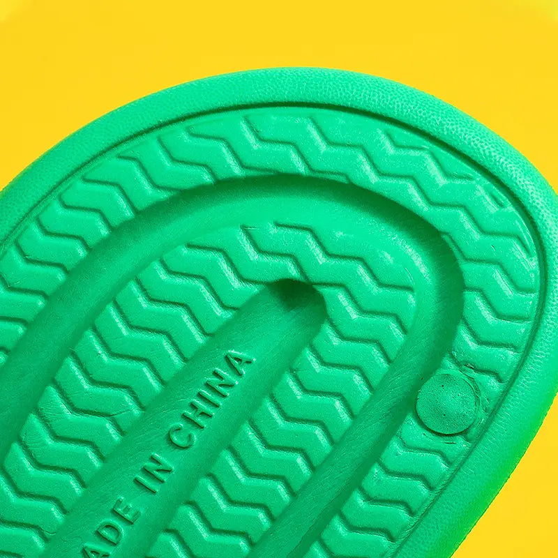 Massage slippers honeycomb textured rubber slides with vibrant green rubber sole featuring a zigzag tread pattern and made in china embossed along the center.