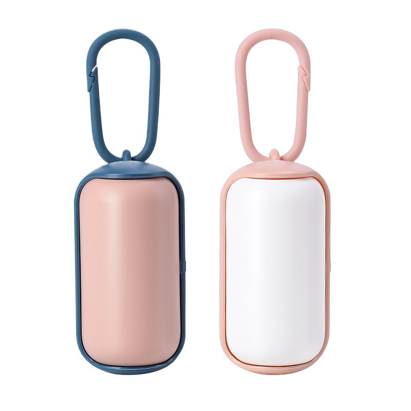 two compact rectangular pet poop bag dispensers with carabiner clips in soft pink with navy blue trim and blush pink with white trim designed for sleek minimalist travel or daily use