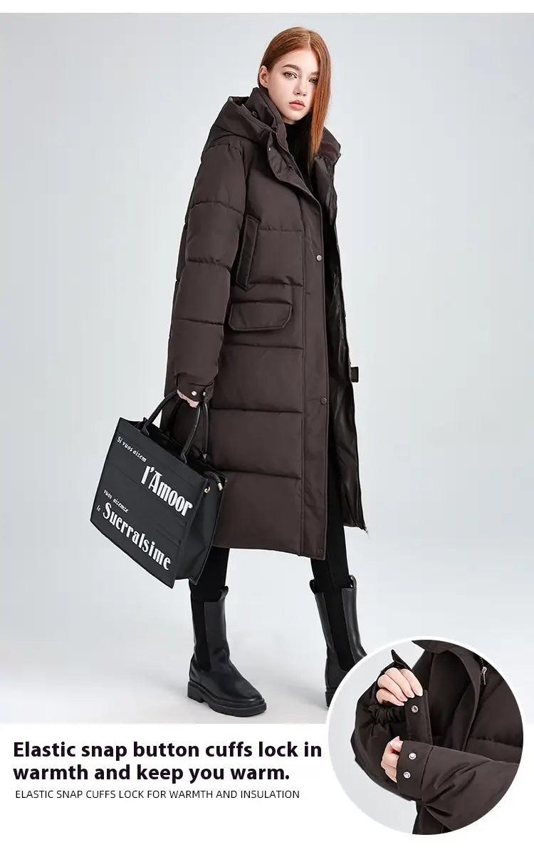 Manteau long matelassé à capuche pour femmes en noir, avec des poignets à boutons-pression élastiques.