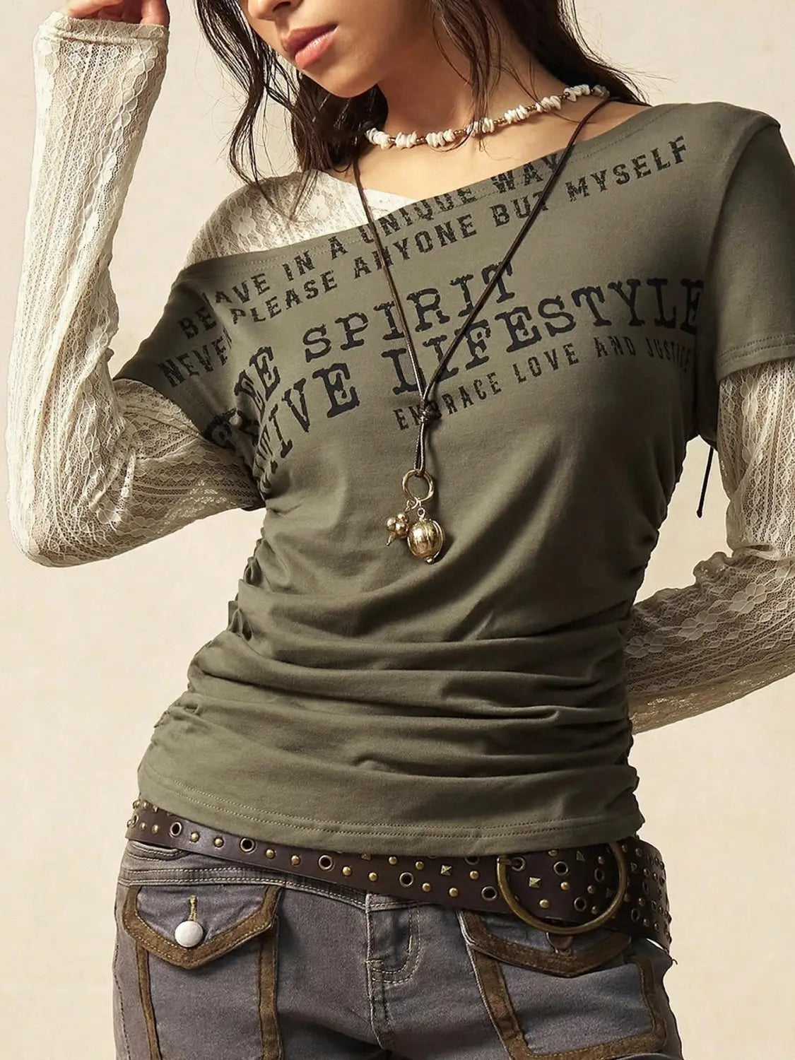 Olive green lace layer off shoulder knitted top with sheer lace long sleeves and bold black text across the chest.