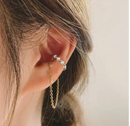 A delicate gold-toned butterfly and diamond alloy ear cuff adorned with small sparkling beads and a dangling chain.