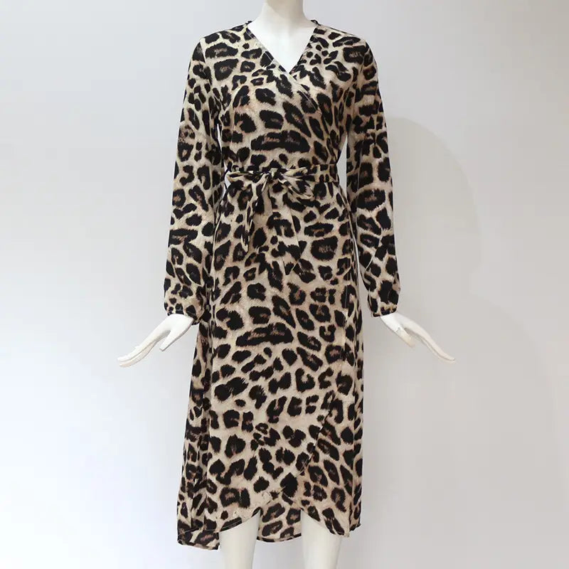 A beige and black leopard print chiffon wrap dress with long sleeves v neck and a self-tie belt.