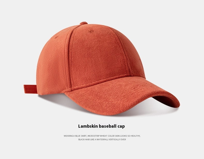 A soft rust-orange suede baseball cap with a curved brim and adjustable fabric strap designed for a minimalist style.