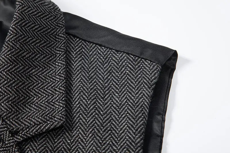 Cuello de abrigo de lana de espiga negra con ribete de satén, que se presenta en un chaleco de traje tipo sastre doble abotonado de espiga para hombre.