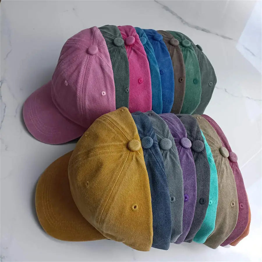A collection of colorful cotton baseball caps in vintage washed corduroy fabric featuring pink blue green yellow and purple hues designed as sun hats.