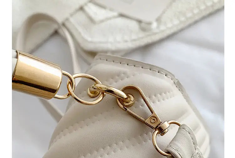 quilted heart clasp crossbody bag with ruched handle featuring a quilted white leather exterior and a gold-toned metal chain strap with cylindrical connector and clasp.