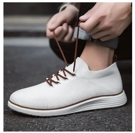 Men’s flyknit casual breathable lace up sneaker in white knit with brown laces and a layered rubber sole.