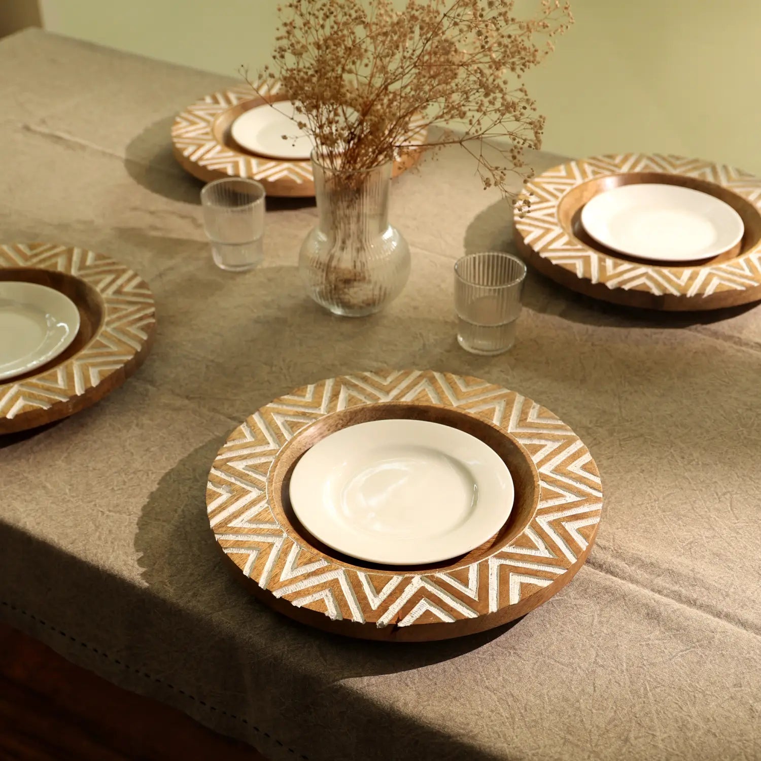 Platos portavelas de madera artesanales con una incrustación geométrica de zigzag de 13 pulgadas en blanco y tonos de madera natural, cada uno con un plato central de cerámica blanca.