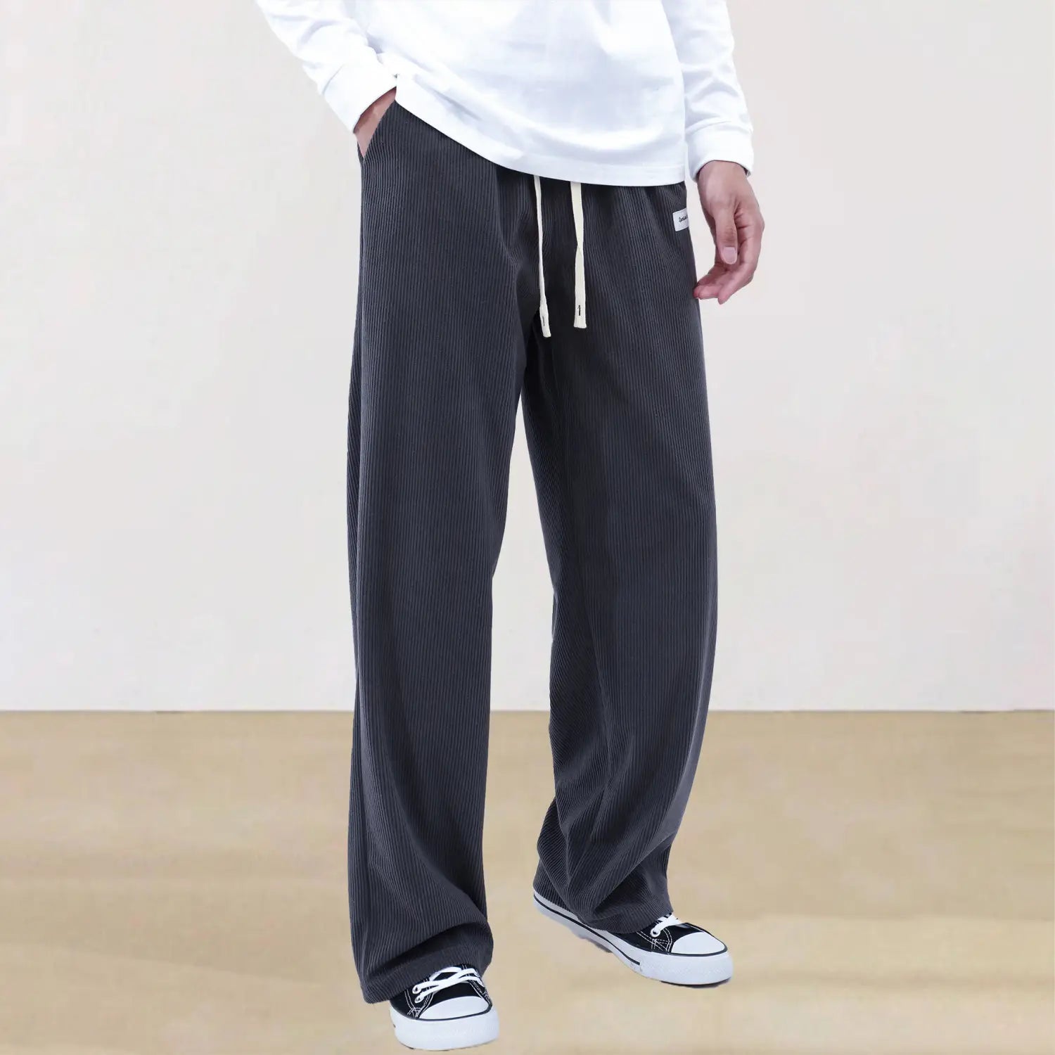 Men’s slim fit dark gray corduroy sport casual pants with vertical ribs and a white drawstring waistband.