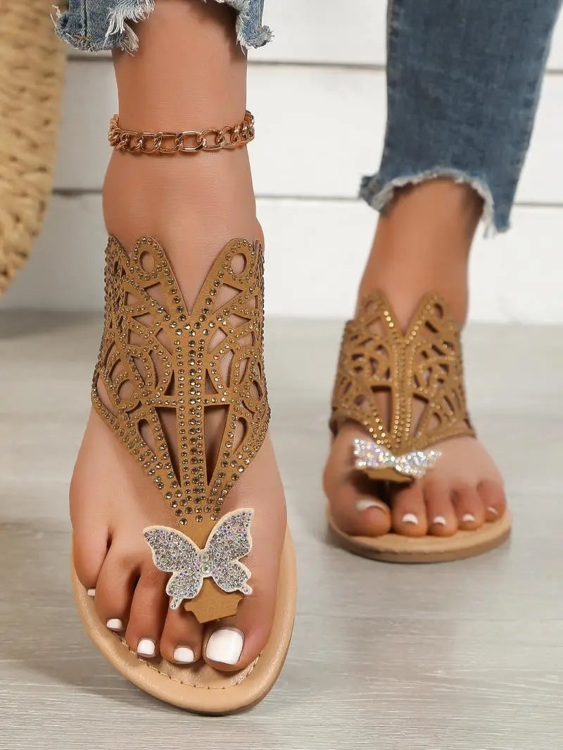 Women’s gold rhinestone hollow flat slip on sandals featuring butterfly embellishments and intricate cutout patterns.