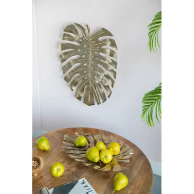 Gold monstera leaf wall decor and serving tray featuring a textured metallic finish and crafted from metal.