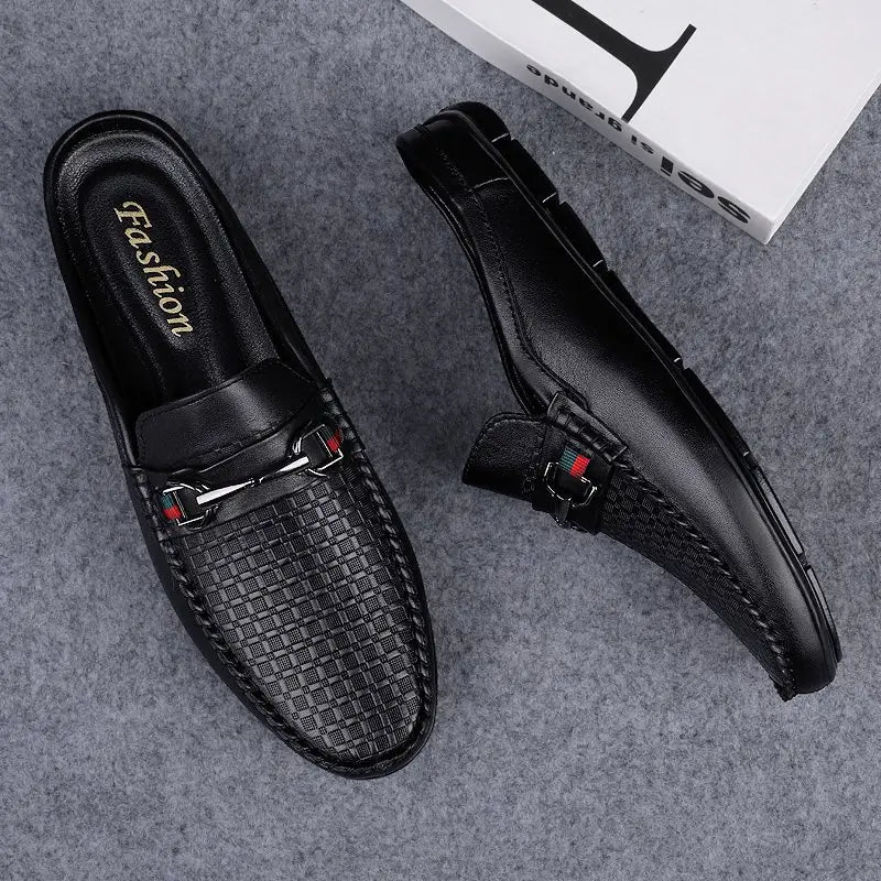 Black leather men’s mule loafers with a woven texture and silver buckle accents.