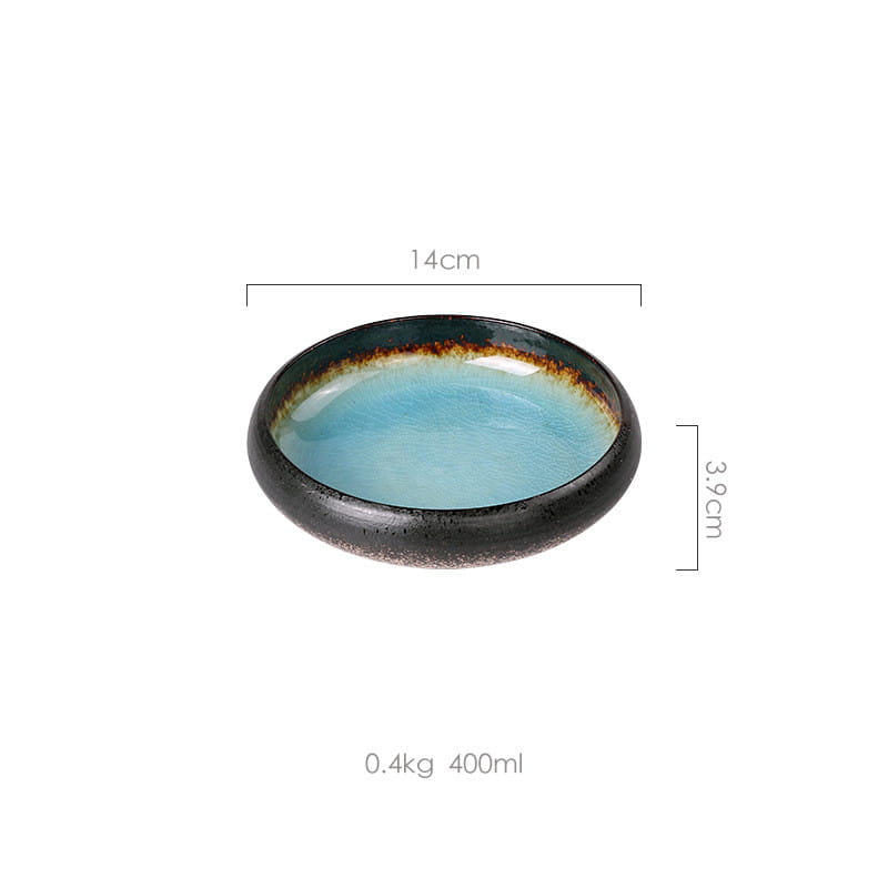 A ceramic bowl kiln glazed bone china round plate with a smooth light blue interior and a dark speckled rim featuring subtle brown glaze accents.