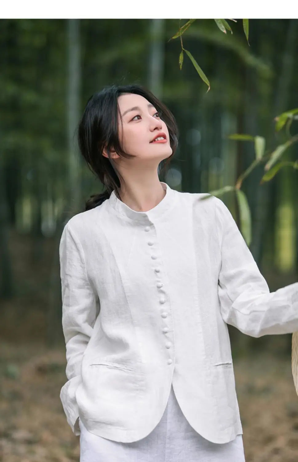 Weiße Leinenbluse mit Knopfleiste vorne und dezenten Falten, kombiniert mit einer Leinen-Patchworkjacke in relaxedem Schnitt.