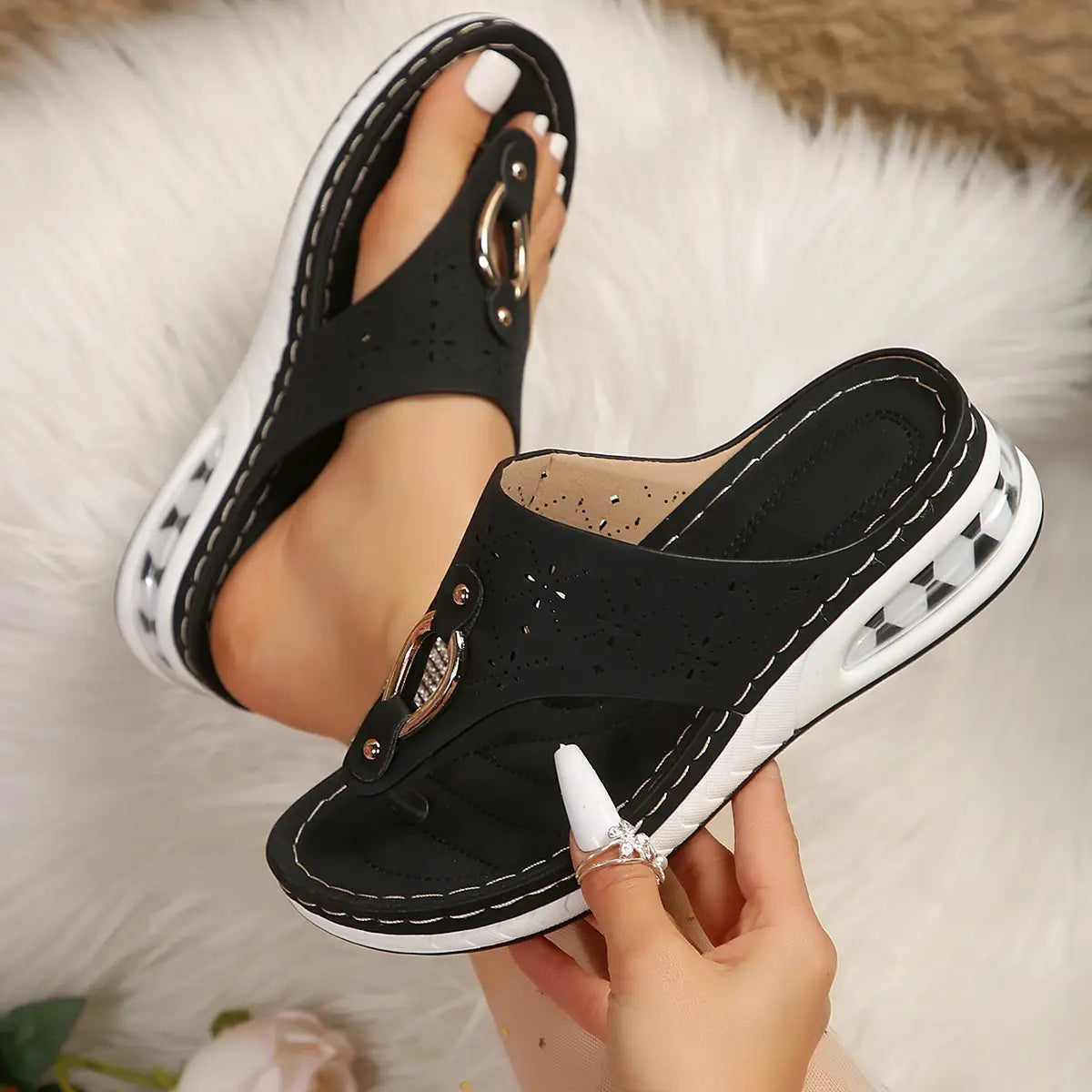 black faux leather air cushion thong sandals with white rubber sole and silver toned metal buckle detail displayed from the back side
