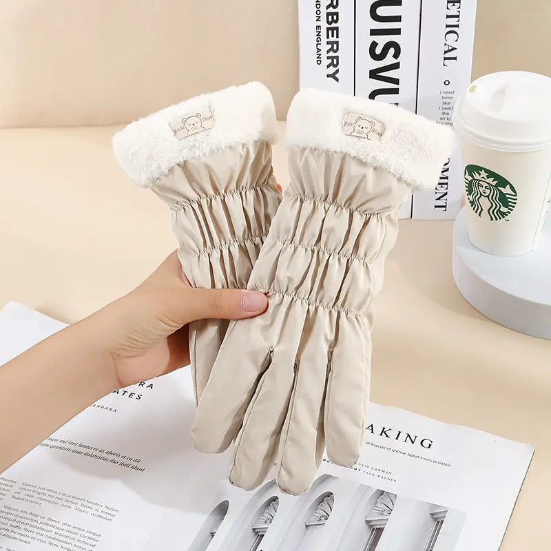 Beige women touch screen winter fleece gloves with plush white fleece cuffs and a cute embroidered bear patch shown from the back side.