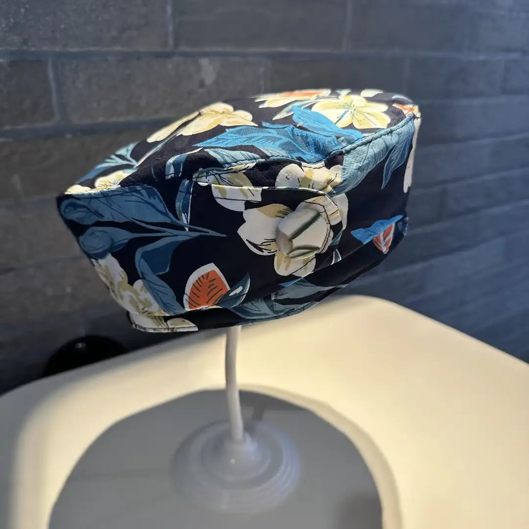A printed Korean style fashion cap cover made of plush material featuring a vibrant floral pattern in shades of blue, yellow, and white on a dark navy background.