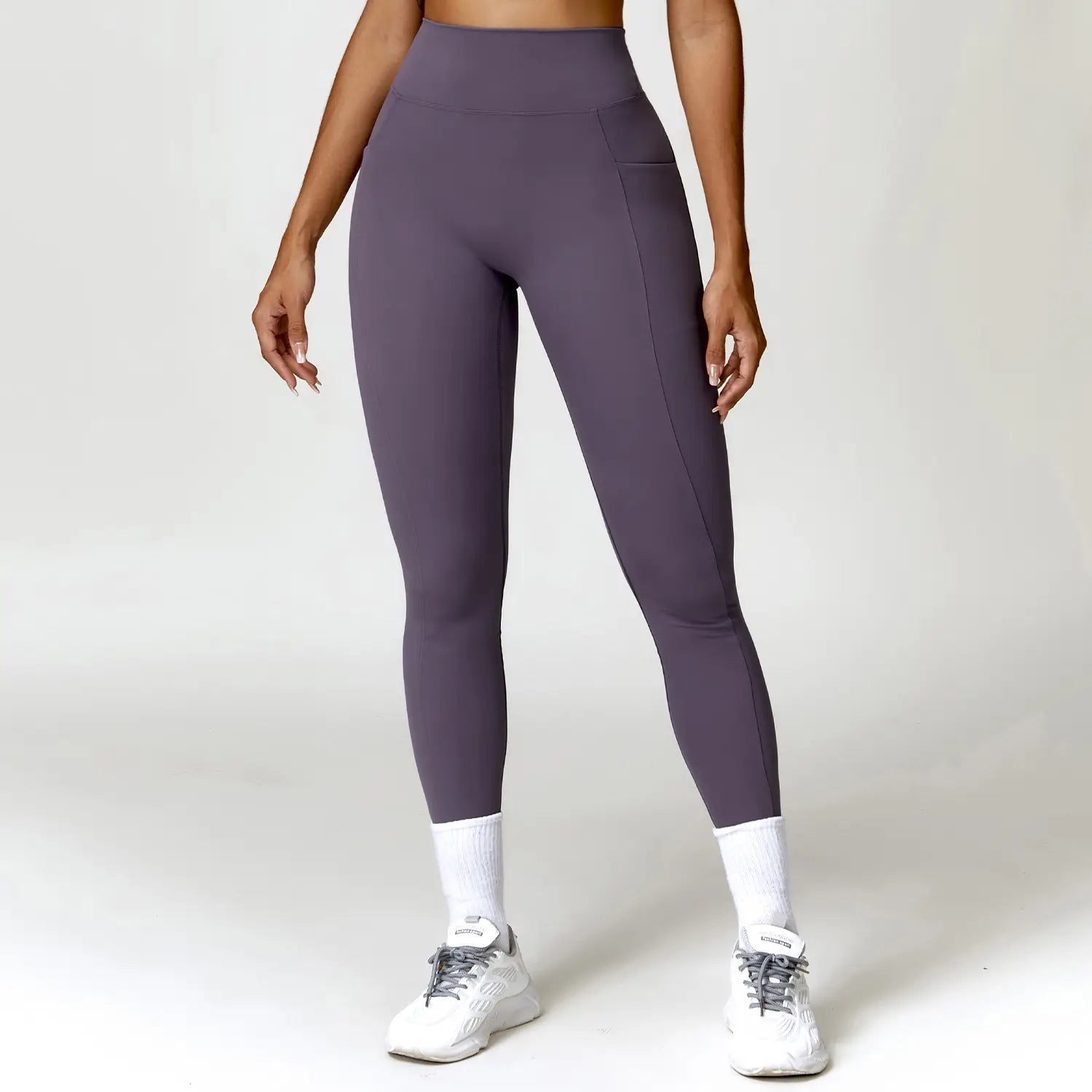 Elite high waisted athletic leggings in purple feature a seamless design with a side pocket, offering a form-fitting and comfortable fit for athletic use.