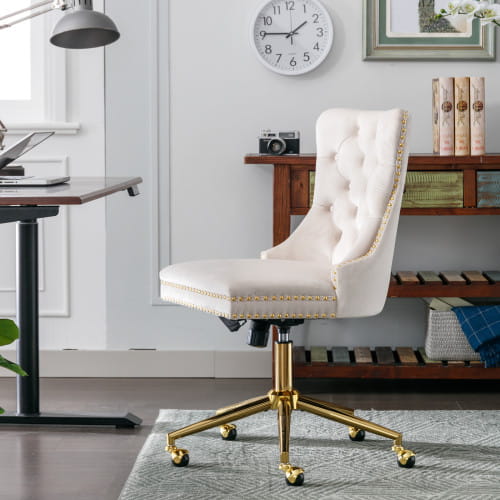 Silla de oficina de terciopelo color crema con botones tipo capitoné, base metálica de tono dorado y remate diseñado para uso en oficina.