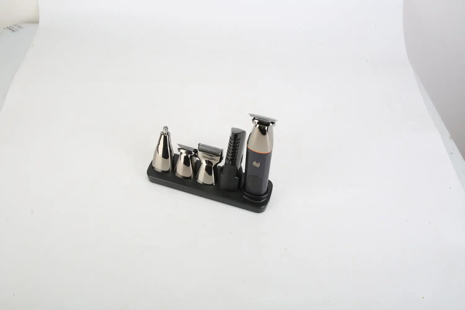 Elektrischer Bartschneider in Schwarz und Silber, 5-in-1, IPX5-wasserdichtes Grooming-Set mit mehreren Aufsätzen, dargestellt auf einem passenden schwarzen Ladeständer.